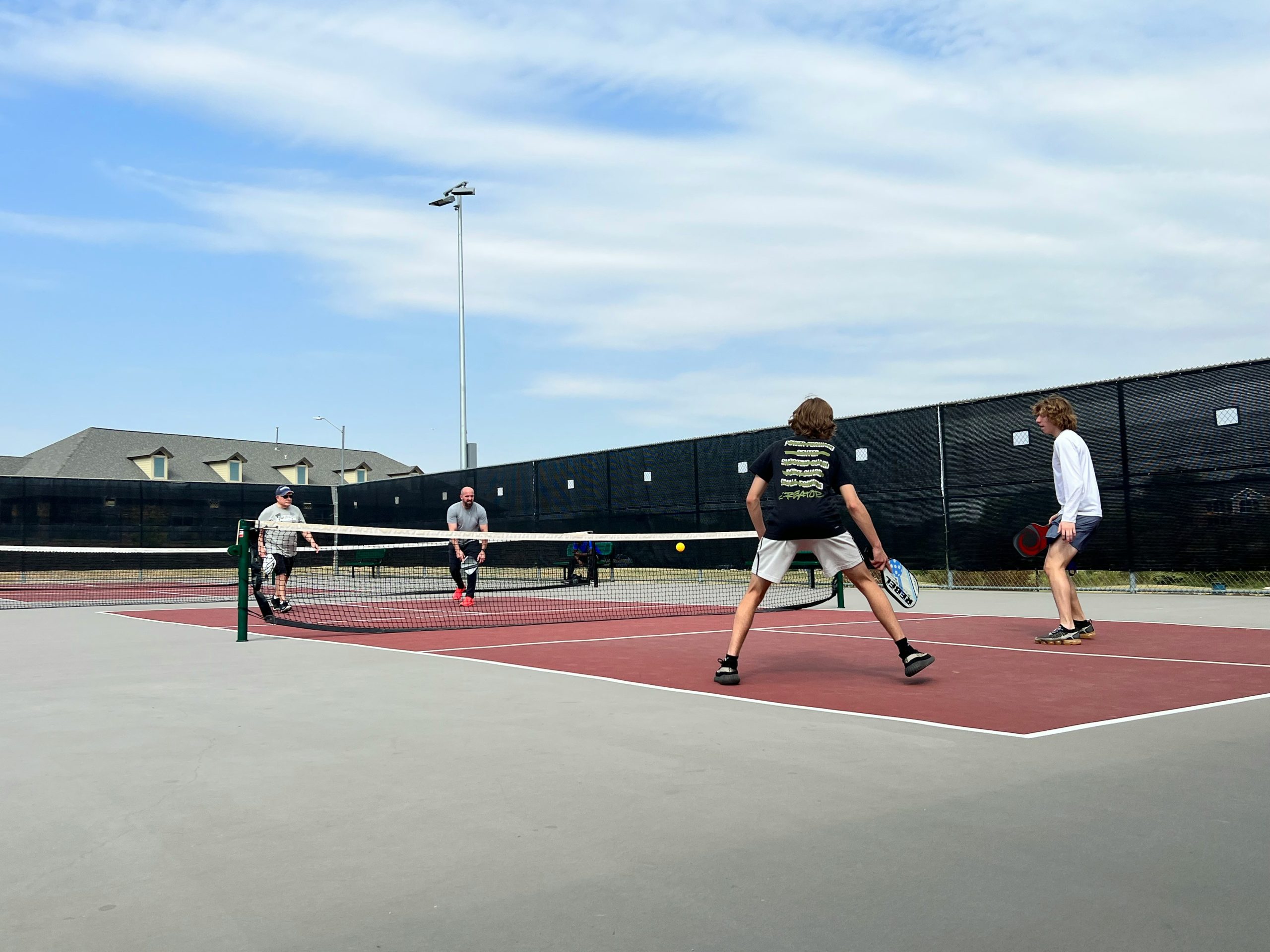 group of people playing pickleball with the best cheap pickleball paddles