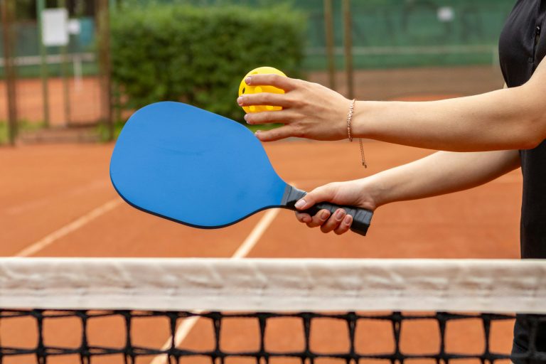 a women holding a pickleball preparing to provide a pickleball paddle weight guide